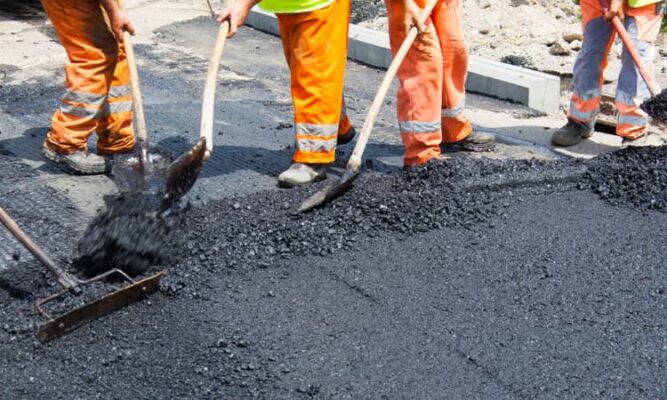 Construction workers laying asphalt