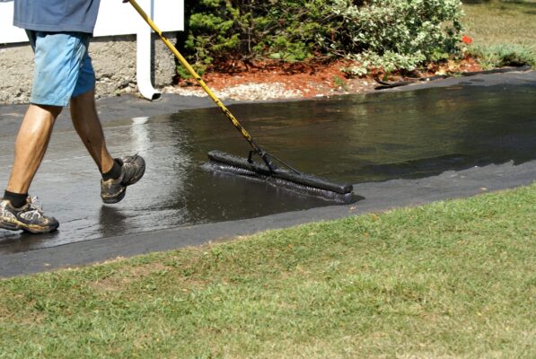 Appying driveway sealer on asphalt driveway